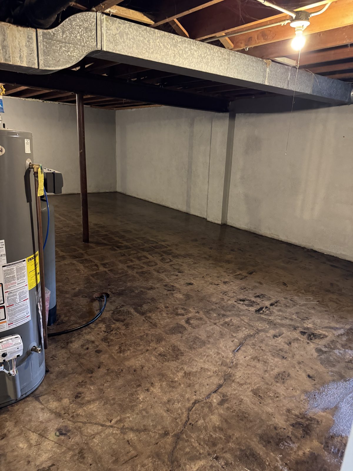 Bare basement slab with old black mastic